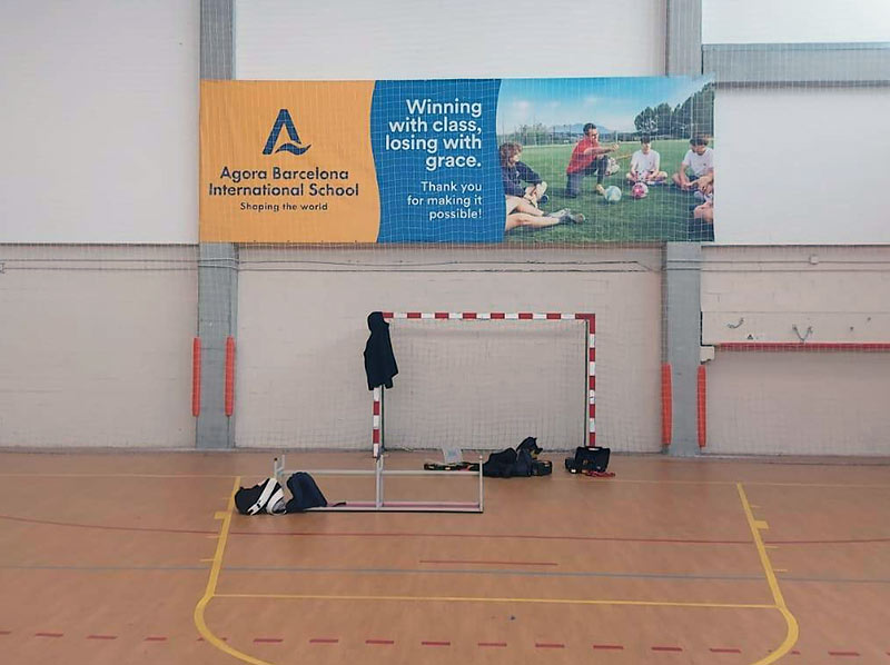 instalación de lona publicitaria en pabellón polideportivo escolar